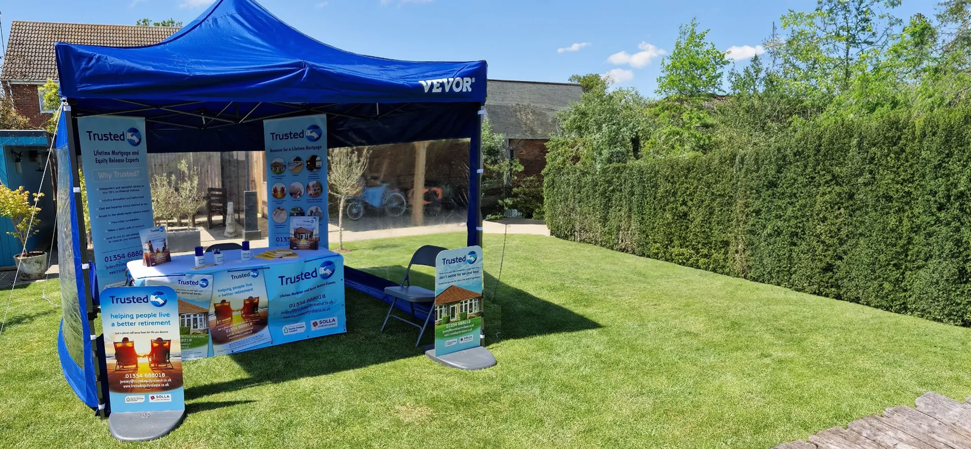 Trusted Equity Release blue gazebo exhibition stand with banners on a lawn